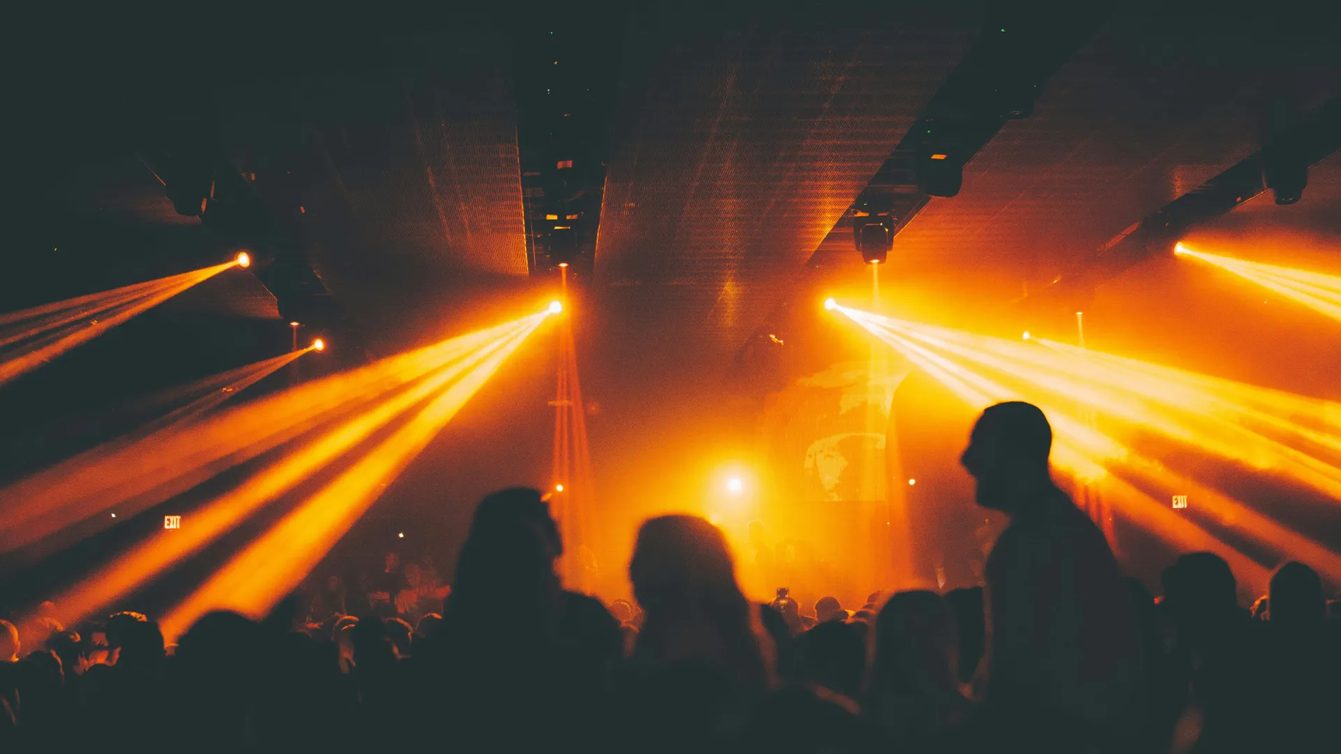 Sfeerbeeld Minimal Rave: dansend publiek in Amare met New European Ensemble en met oranje lichtstralen.